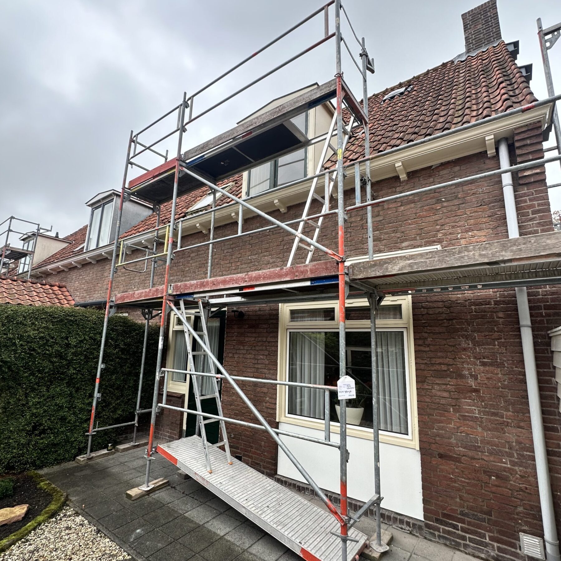 Buitenschilderwerk Schoonhoven – RAL 1015 & RAL 6009 Steigerwerk bij buitenschilderwerk woning Schoonhoven