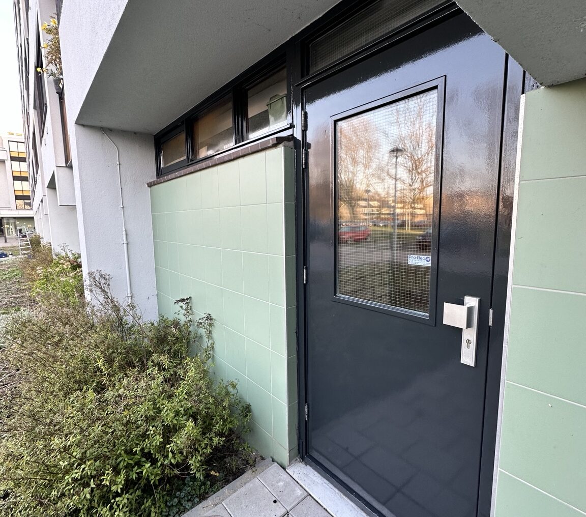 Schuurportiek schilderwerk Krimpen Schilderwerk schuurportiek en bergingsdeur seniorenflat Krimpen aan den IJssel – RAL 7021 zwartgrijs