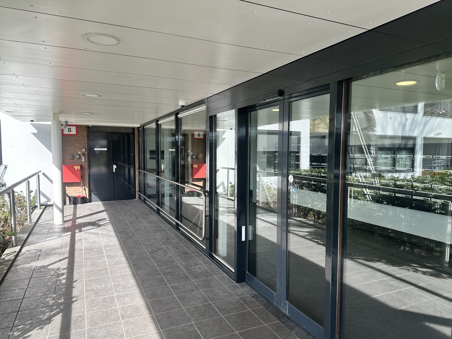 Onderhoudsschilderwerk seniorenflat Krimpen aan den IJssel met kozijnen en deuren in RAL 7021 zwartgrijs, afgewerkt met Veveo Celsor Platina SB 4S