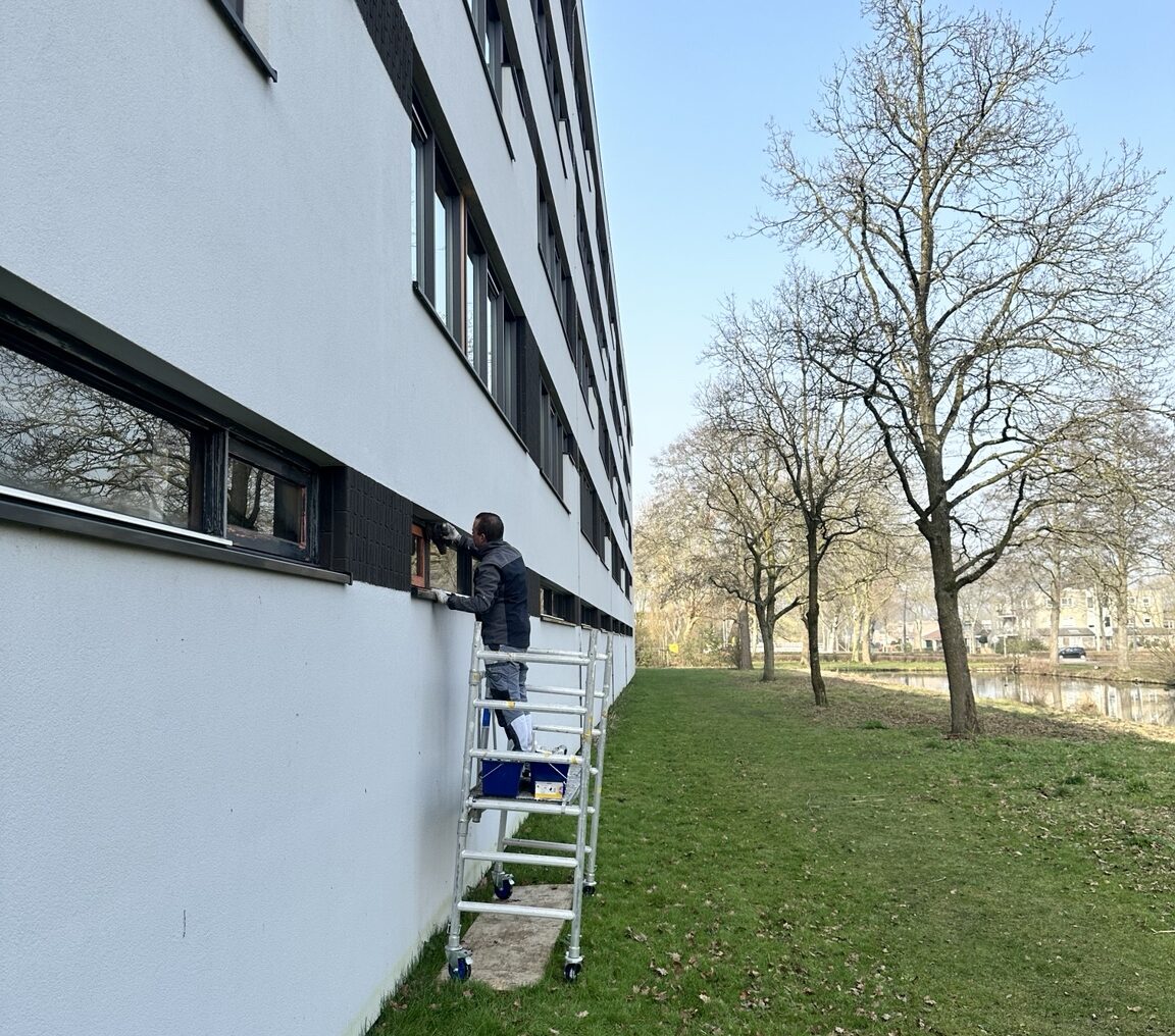 schilderwerk-seniorenflat-krimpen-kozijnen-begane-grond-werkzaamheden Schilderwerk werkzaamheden aan kozijnen seniorenflat Krimpen aan den IJssel – begane grond in RAL 7021 zwartgrijs