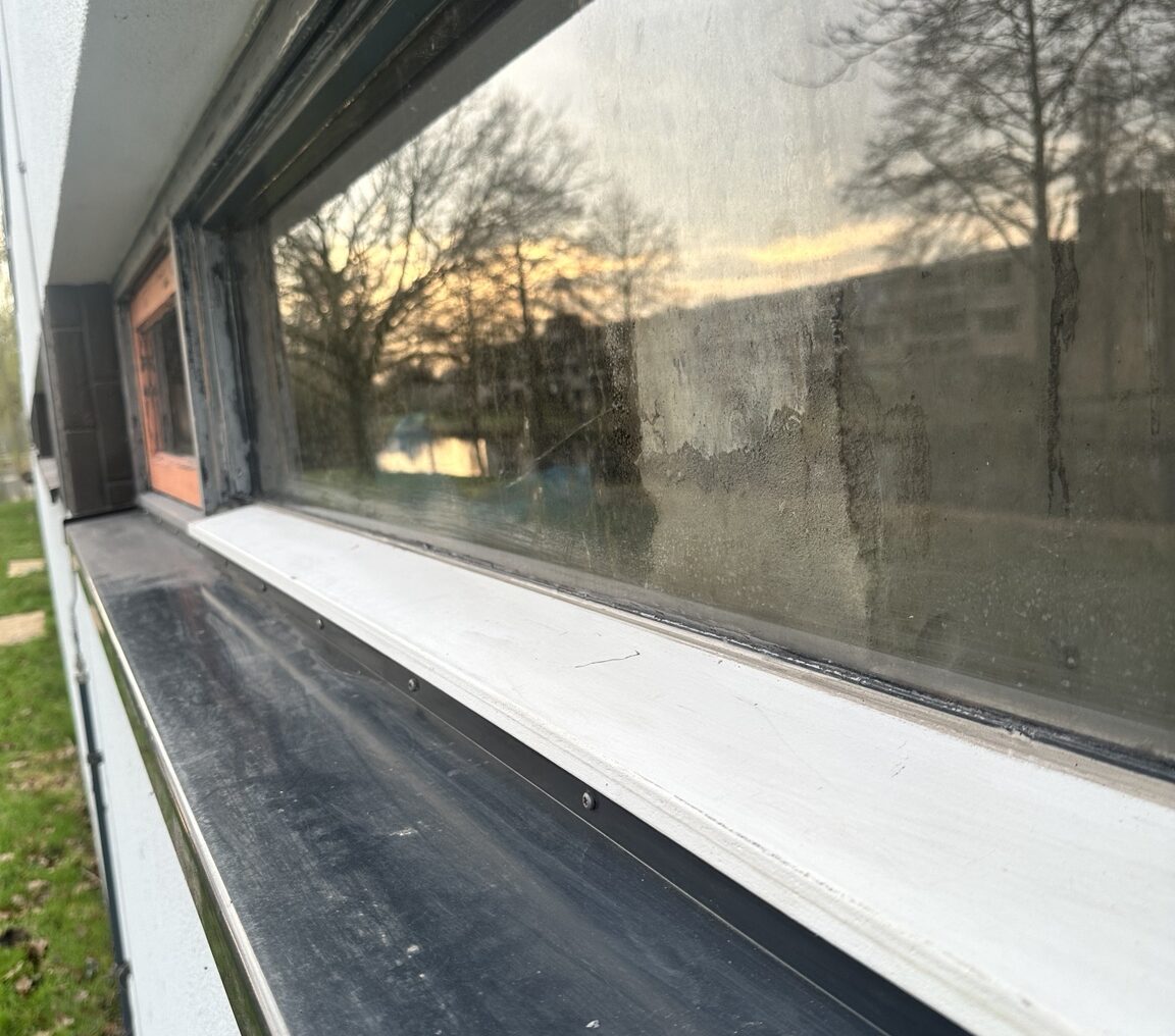 Ventistone glaslatten schilderwerk Krimpen Ventistone glaslatten bij kozijnen seniorenflat Krimpen aan den IJssel – geschilderd in RAL 7021 zwartgrijs