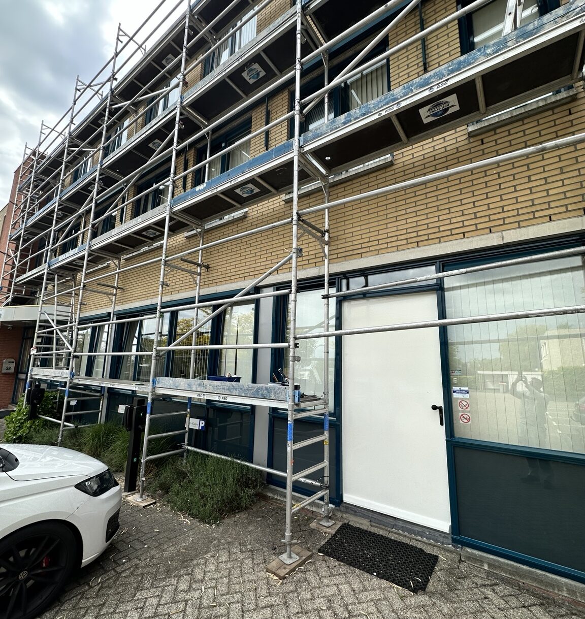 Buitenschilderwerk bedrijfspand met steigerwerk